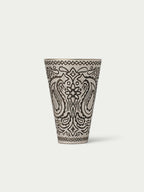 Paisley-patterned cone cup with black line art on a cream base, top rim visible