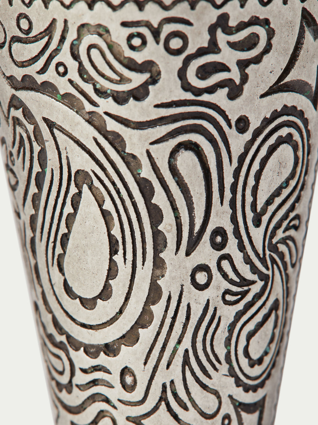 Close-up of paisley pattern on a cream cone cup with dark ornamental linework