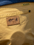 Tan canvas dungaree pants back pocket with leather patch and horse logo
