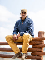 Tan dungaree pants with belt loops and front pockets, worn with work boots