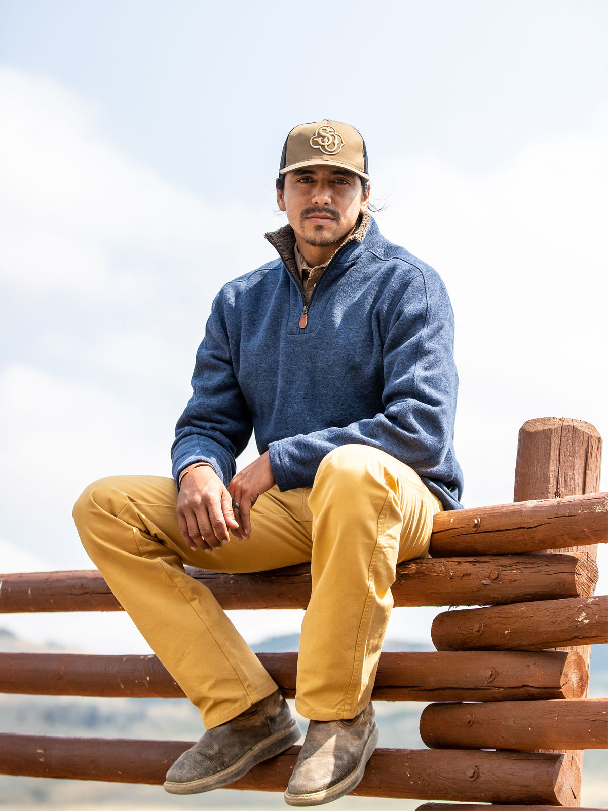 Tan dungaree pants with belt loops and front pockets, worn with work boots