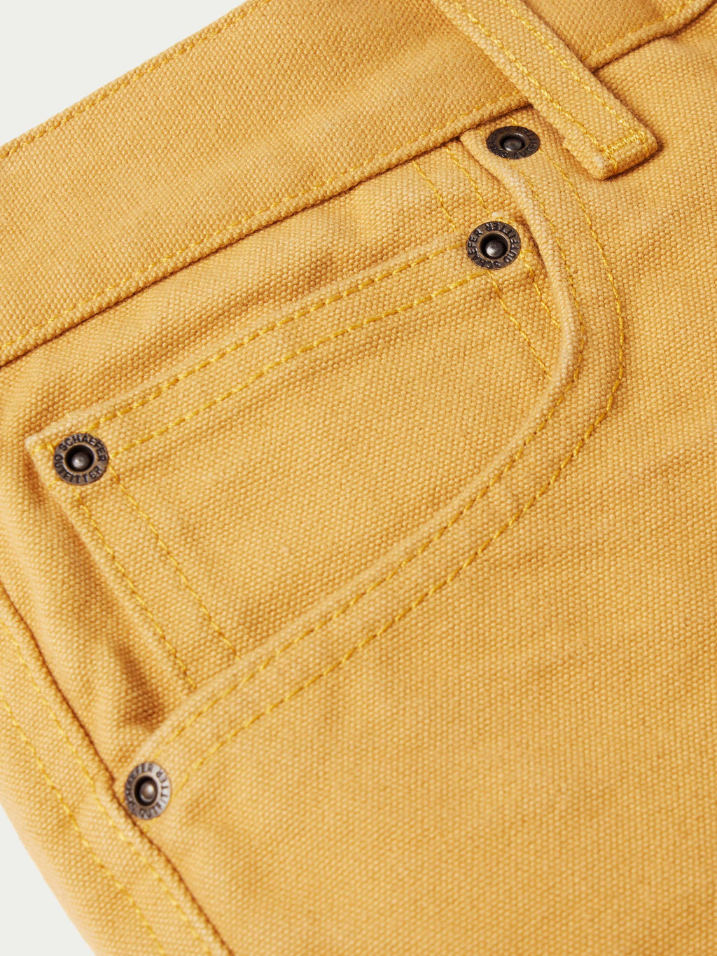 Tan canvas dungaree pants waistband with metal snaps and belt loops