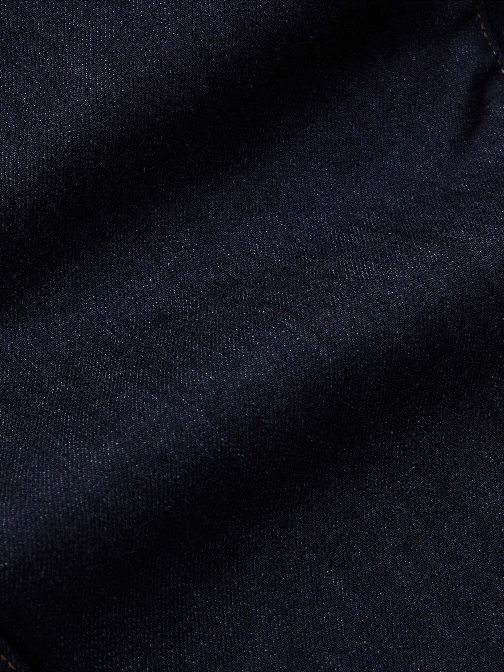 Dark rinse denim fabric texture close-up