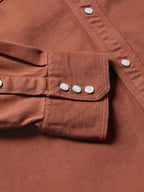 Brick denim snap shirt close-up of chest pocket with snap flap and sleeve cuff