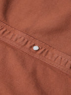 Brick denim snap detailing on shoulder yoke seam with silver button
