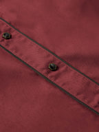 Mahogany snap shirt seam close-up with black piping and metal stud snaps