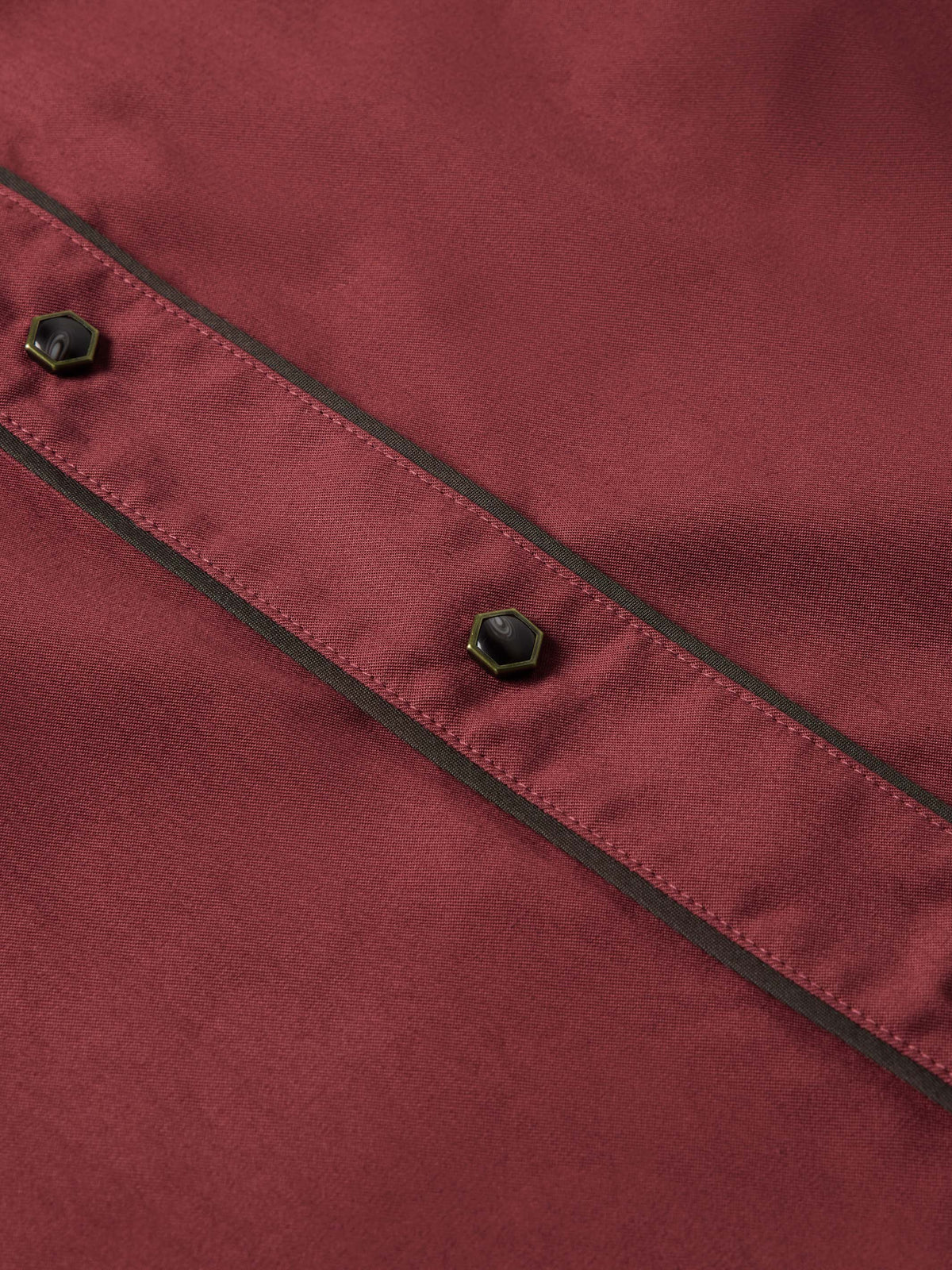 Mahogany snap shirt seam close-up with black piping and metal stud snaps