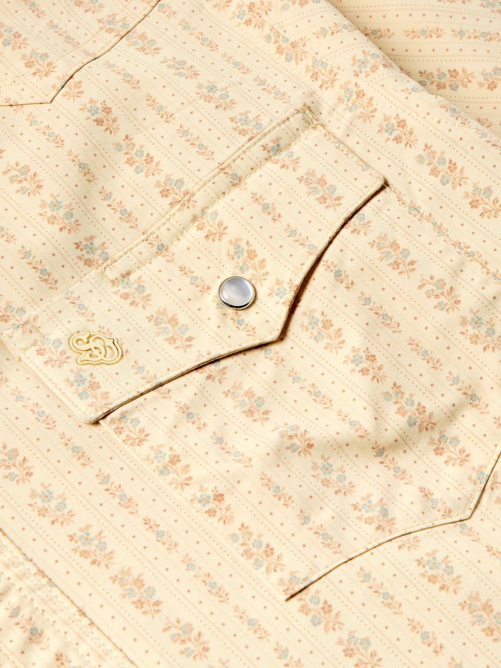 Detail of short sleeve pearl snap western shirt: metal snaps and decorative chest stitch.
