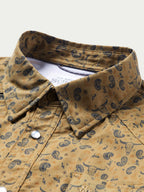 Short sleeve western shirt collar close-up with pearl snap placket and patterned fabric.