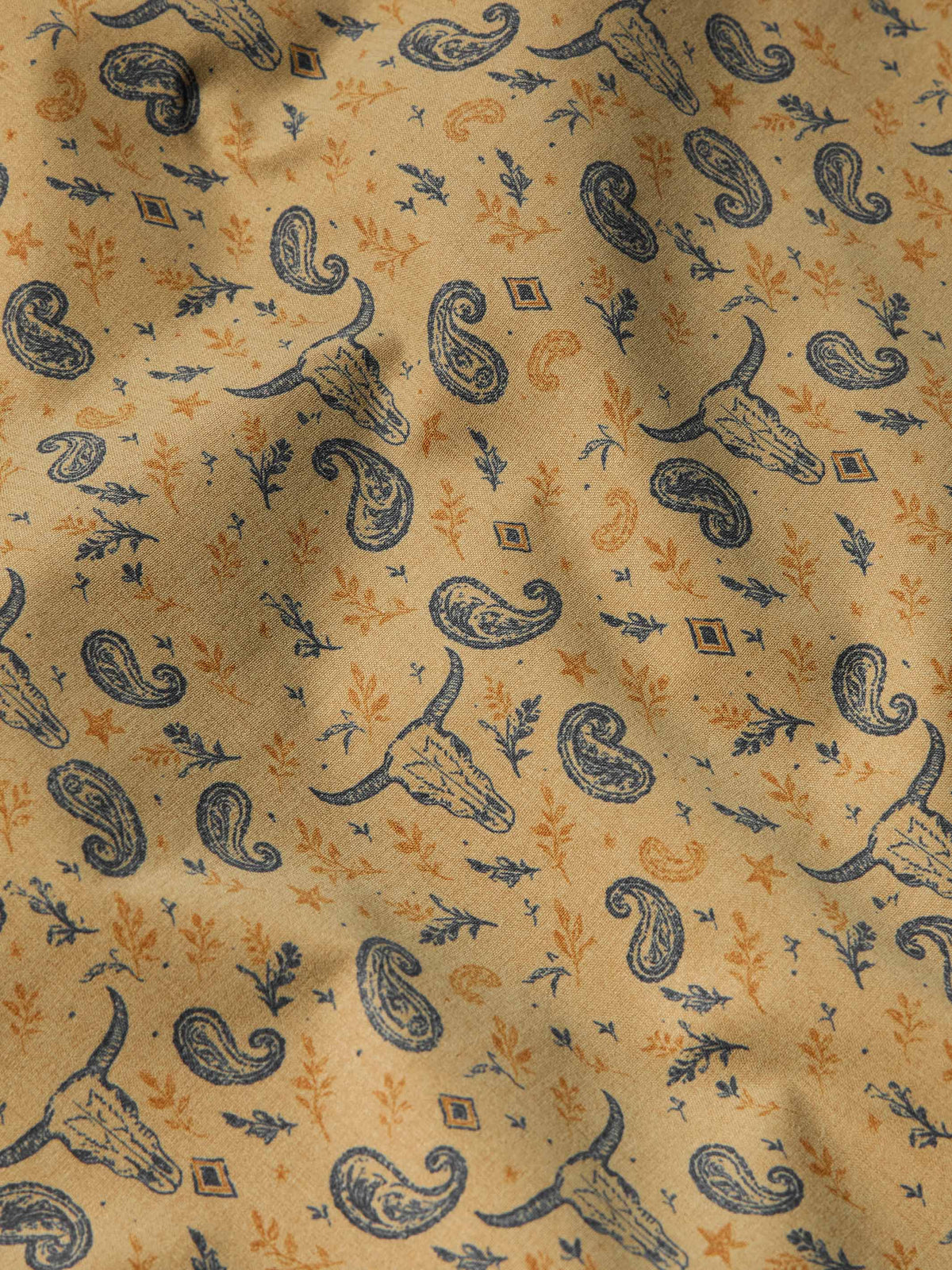 Paisley print fabric for a short sleeve western shirt in golden tan with blue accents.