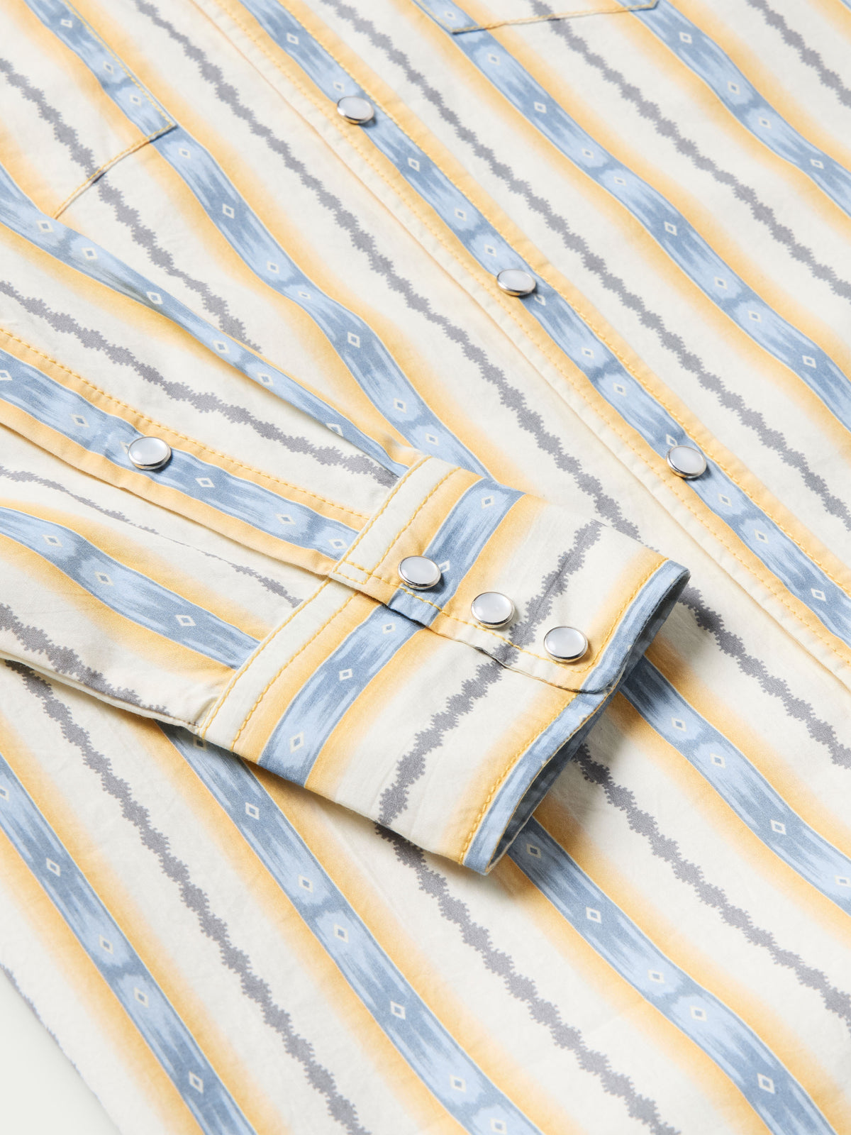 Cotton snap shirt front detail with light blue and white vertical stripes and white snap buttons