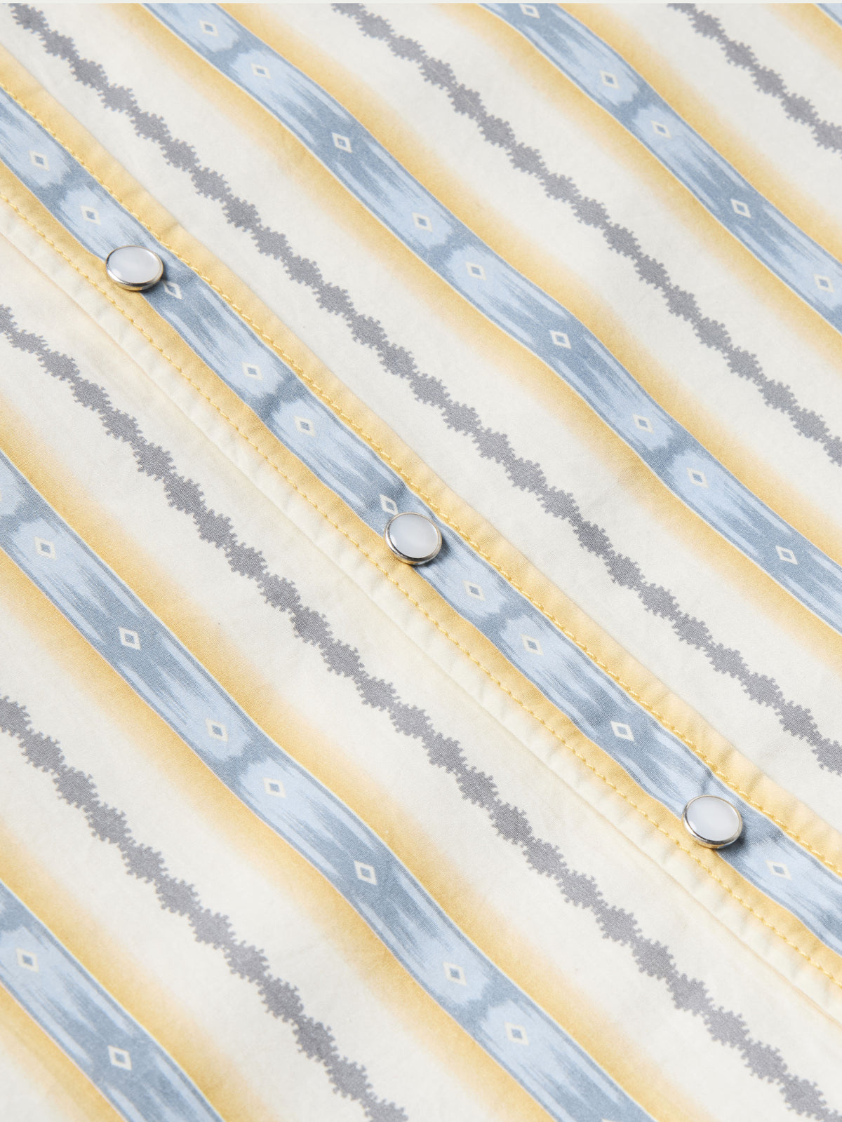 Cotton snap shirt front placket close-up with light blue and white vertical stripes
