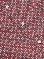 Cotton snap shirt close-up in dark red with repeating geometric pattern and metal snaps.