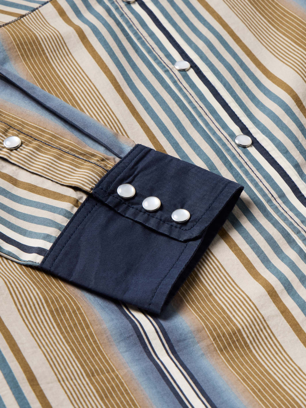 Cotton snap shirt cuff and sleeve tab detail, blue/tan stripes with navy snaps