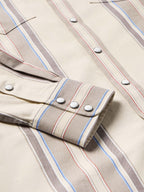 Western snap shirt in tan with blue and red vertical stripes, cuff snap detail