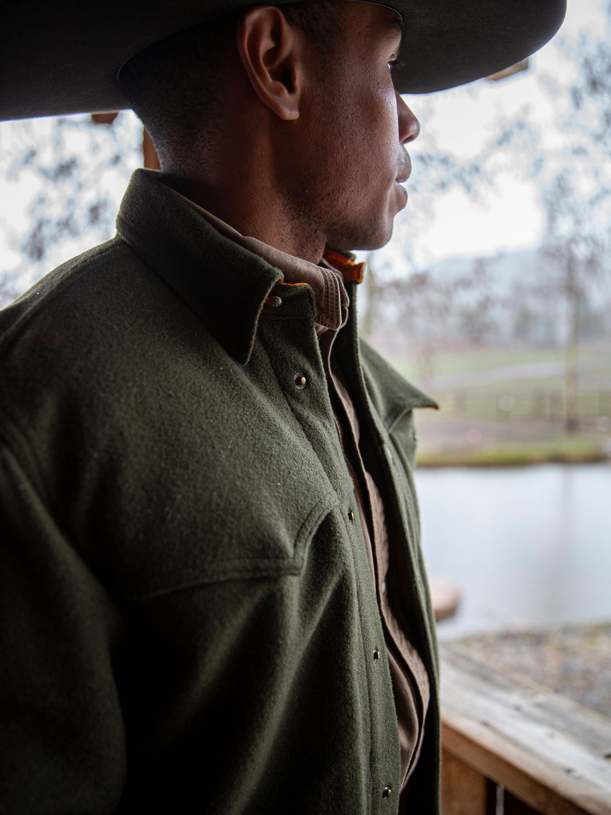 Olive wool overshirt with buttoned collar, worn in profile