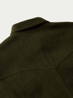 Olive wool overshirt close-up of shoulder seam and collar edge.