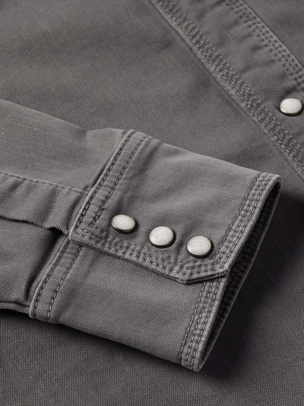 Men's western denim snap shirt sleeve cuff with two-snap button closure.