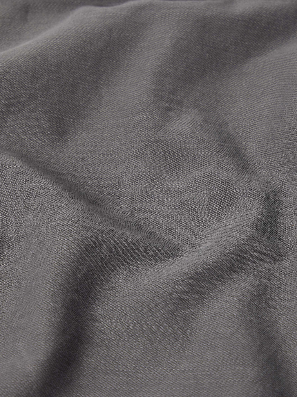 Dark carbon gray denim fabric close-up from a men's western snap shirt.