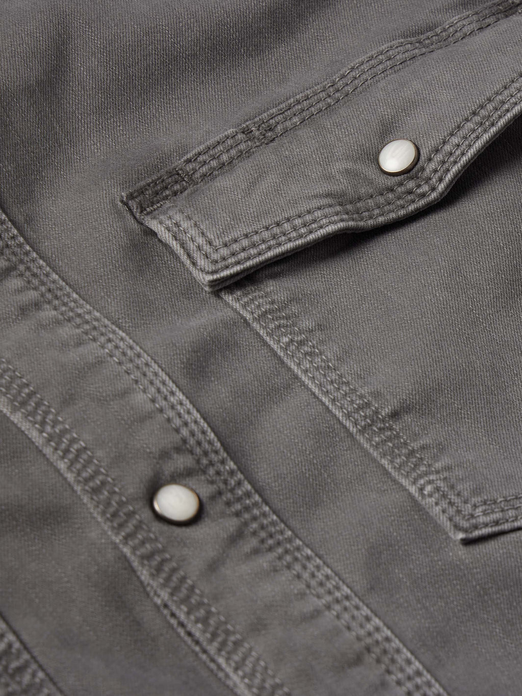 Men's western denim snap shirt front placket and pocket flap with snap buttons.