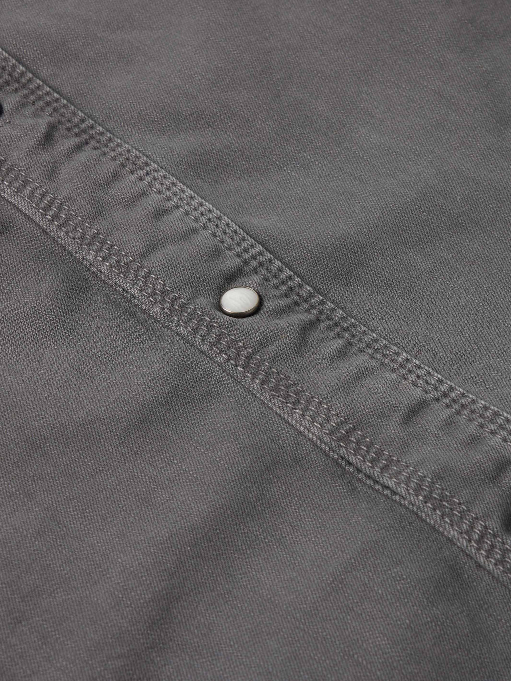 Men's western denim snap shirt neckline and button placket detail with snap hardware.