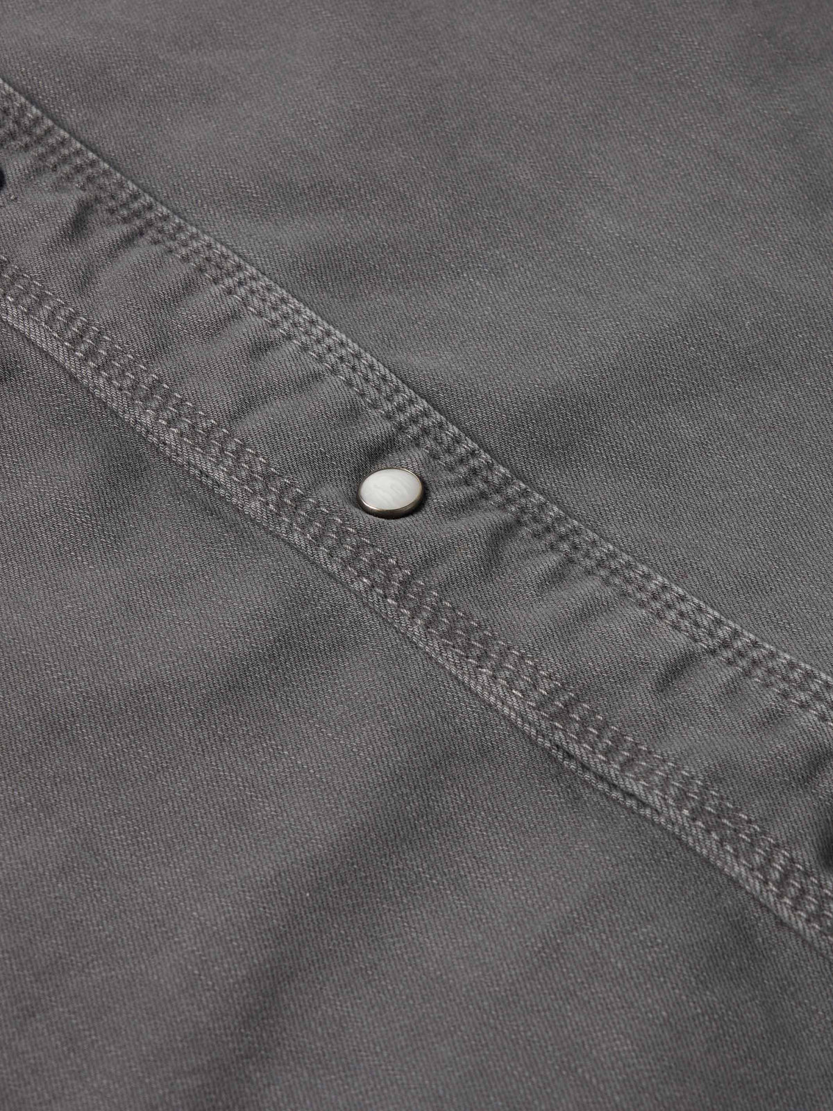 Men's western denim snap shirt neckline and button placket detail with snap hardware.