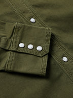 Dark olive denim snap shirt cuff with white snap buttons and pocket flap