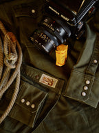 Dark olive denim snap shirt close-up with metal snaps and embroidered front pocket patch