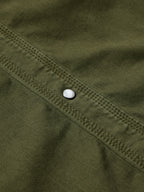 Dark olive denim snap shirt sleeve seam with white snap button