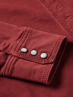 Rust Western denim shirt cuff with three snap buttons and stitched placket