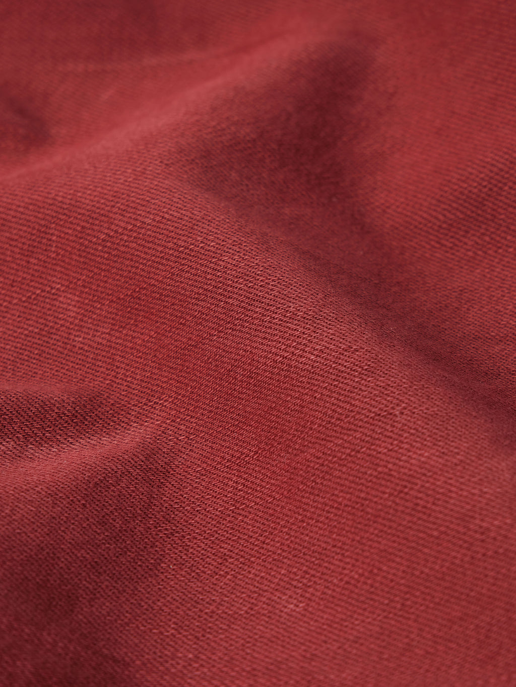 Rust denim fabric texture close-up with fine crosshatch topstitching