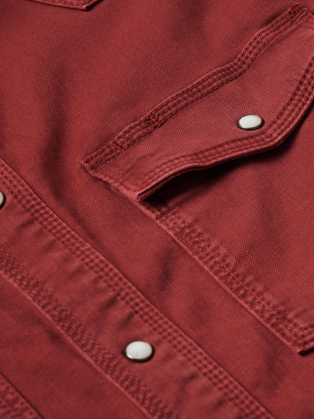 Rust Western denim shirt sleeve cuff with snap tab and visible topstitching