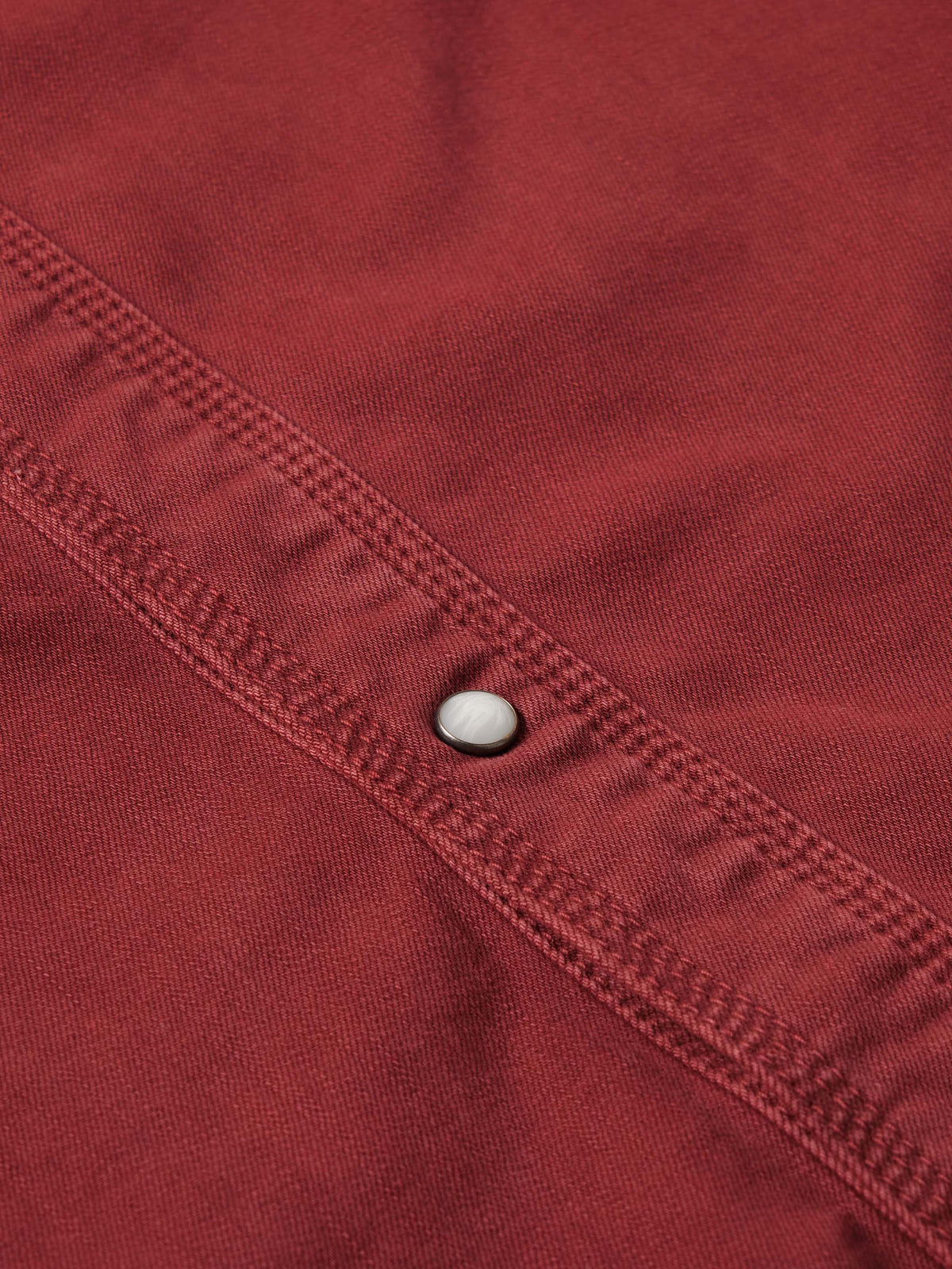 Rust Western denim shirt seam and snap-front placket detail