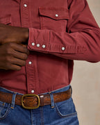 Rust denim snap shirt cuff with snap buttons and chest panel detail.