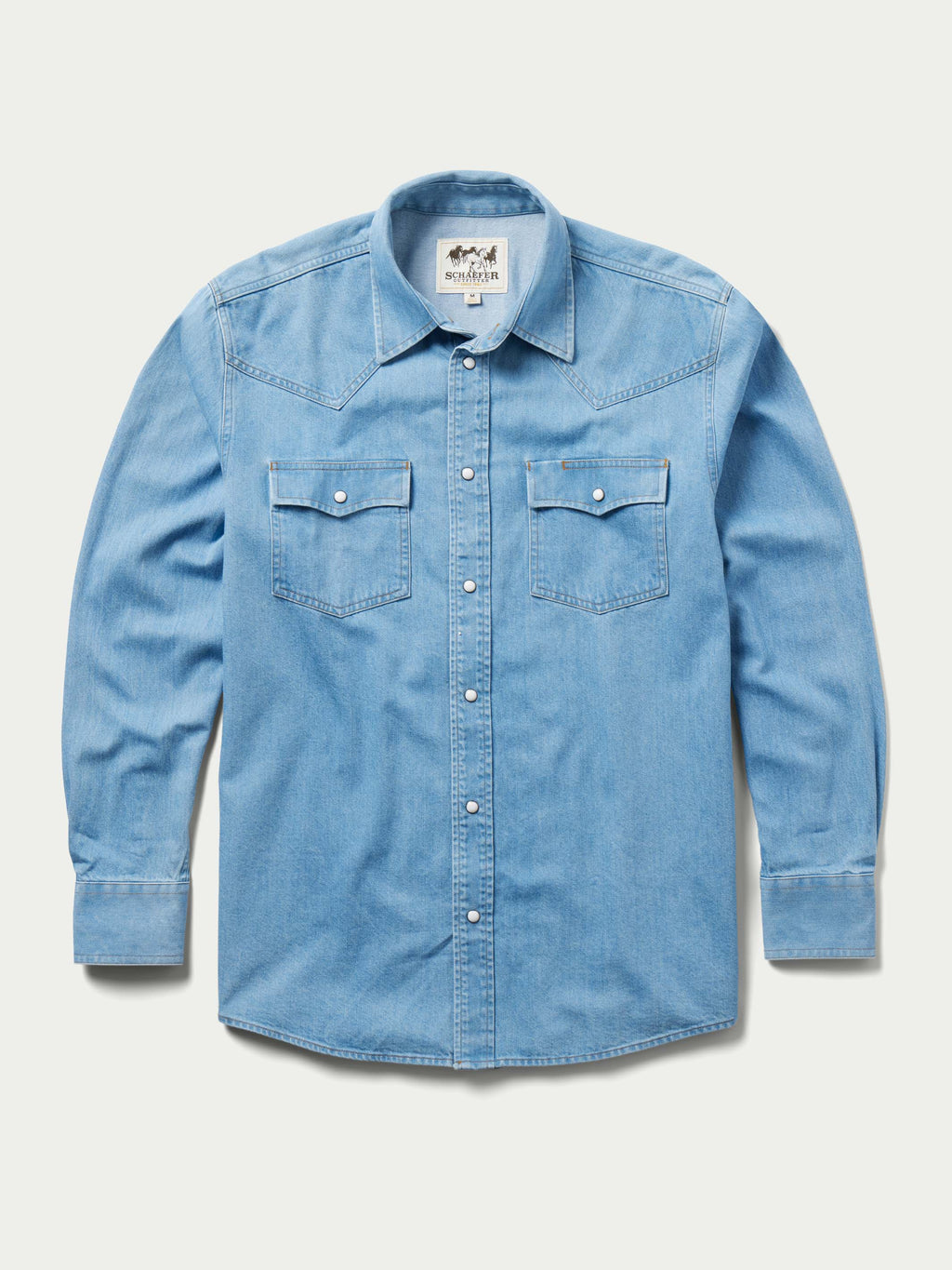 Light-wash denim snap shirt front view, long sleeves with two chest snap pockets