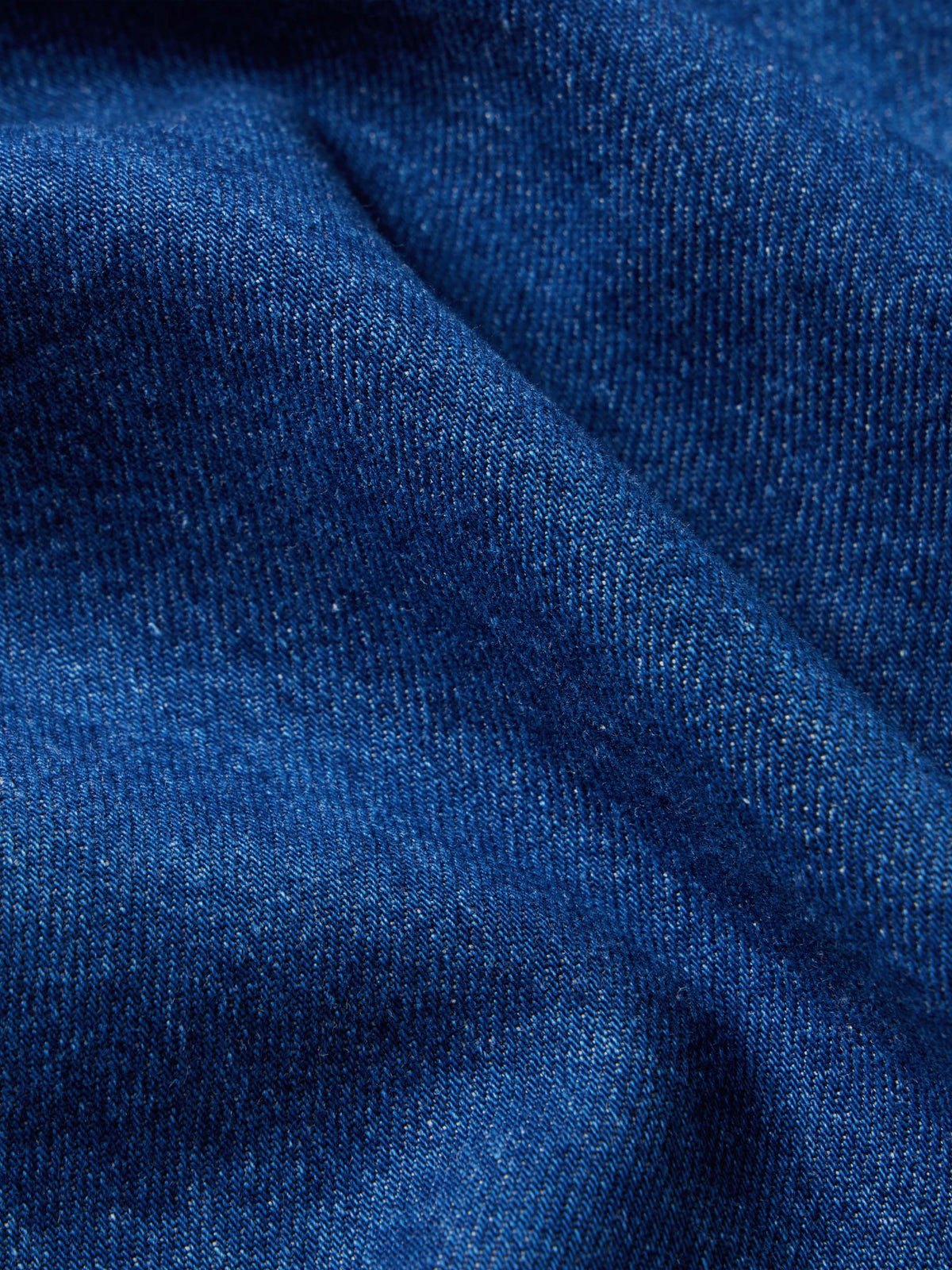 Dark indigo denim snap shirt fabric texture close-up