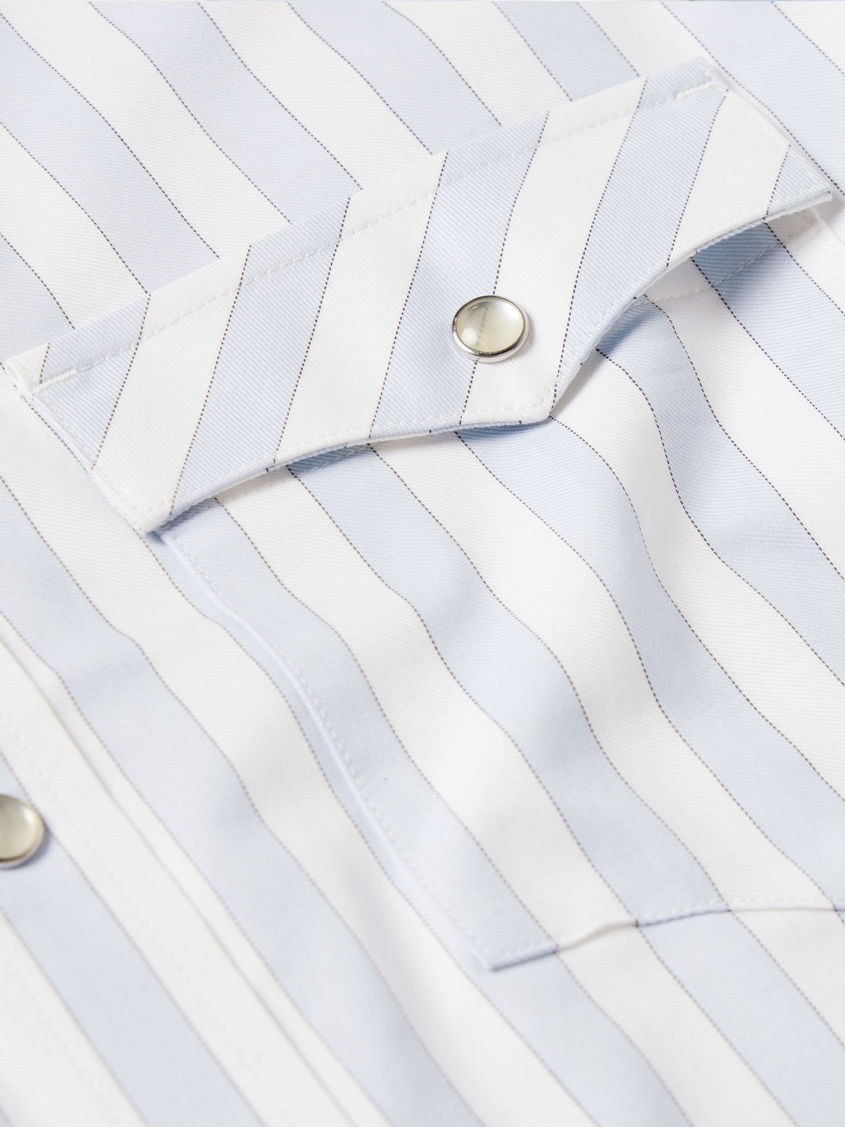 Light blue striped Western shirt cuff with snap button detail on fabric