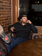 Black western button-down shirt worn by a man, long sleeves and snap front