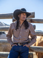 Model wearing a western striped snap button-down shirt with chest pockets