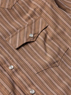 Close-up of western striped shirt chest pocket with snap flap and metal snap buttons