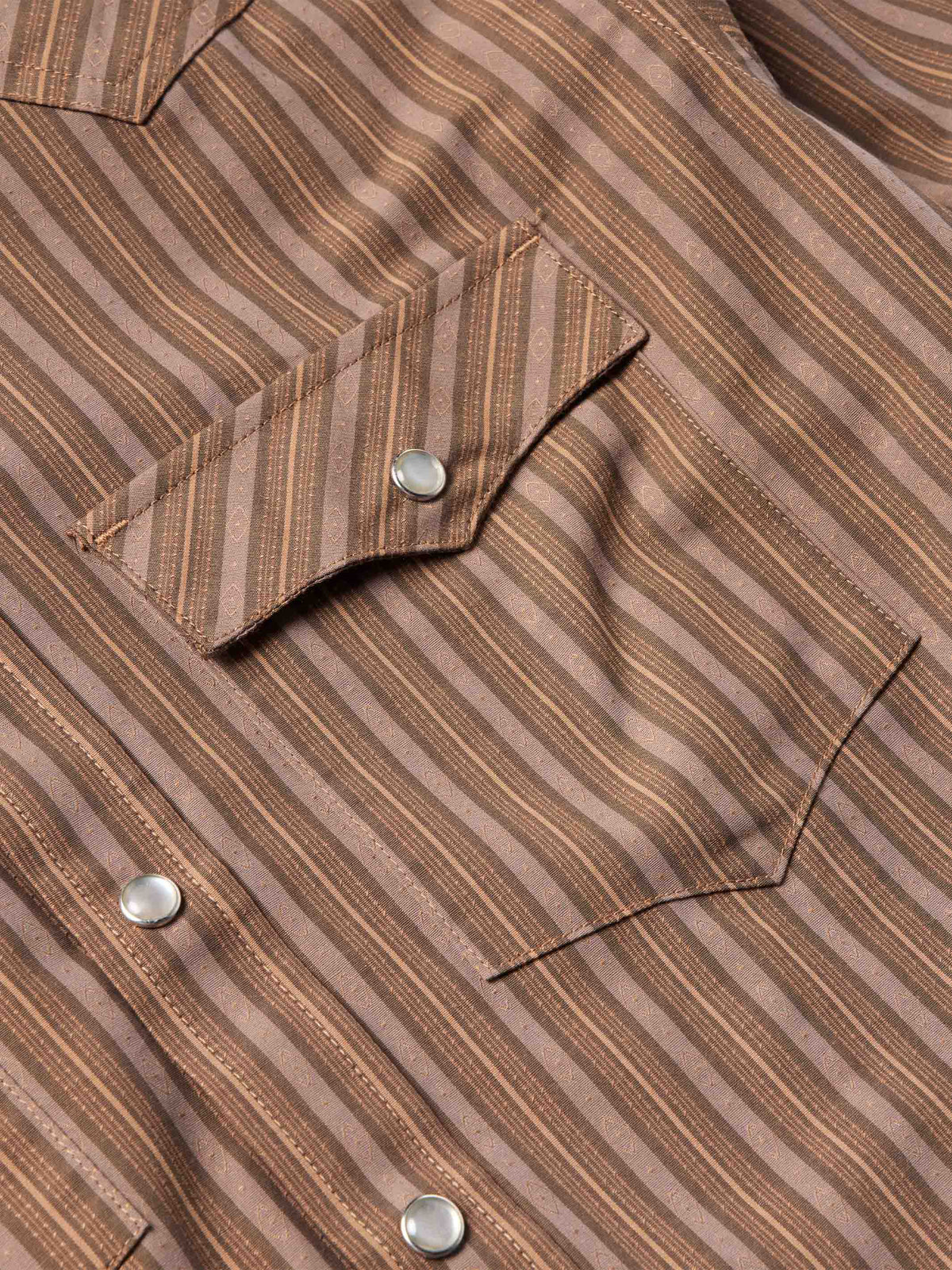 Close-up of western striped shirt chest pocket with snap flap and metal snap buttons