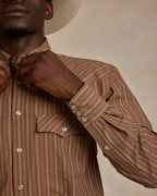 Close-up of model adjusting western striped snap button cuffs with metal buttons