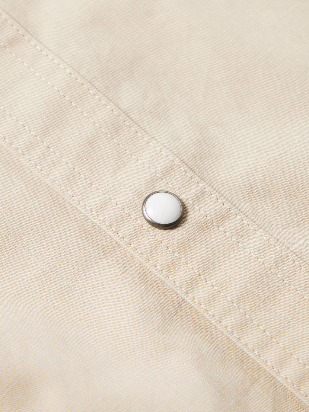 Light beige shirt placket with snap button and stitched panel