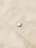 Light beige shirt placket with snap button and stitched panel