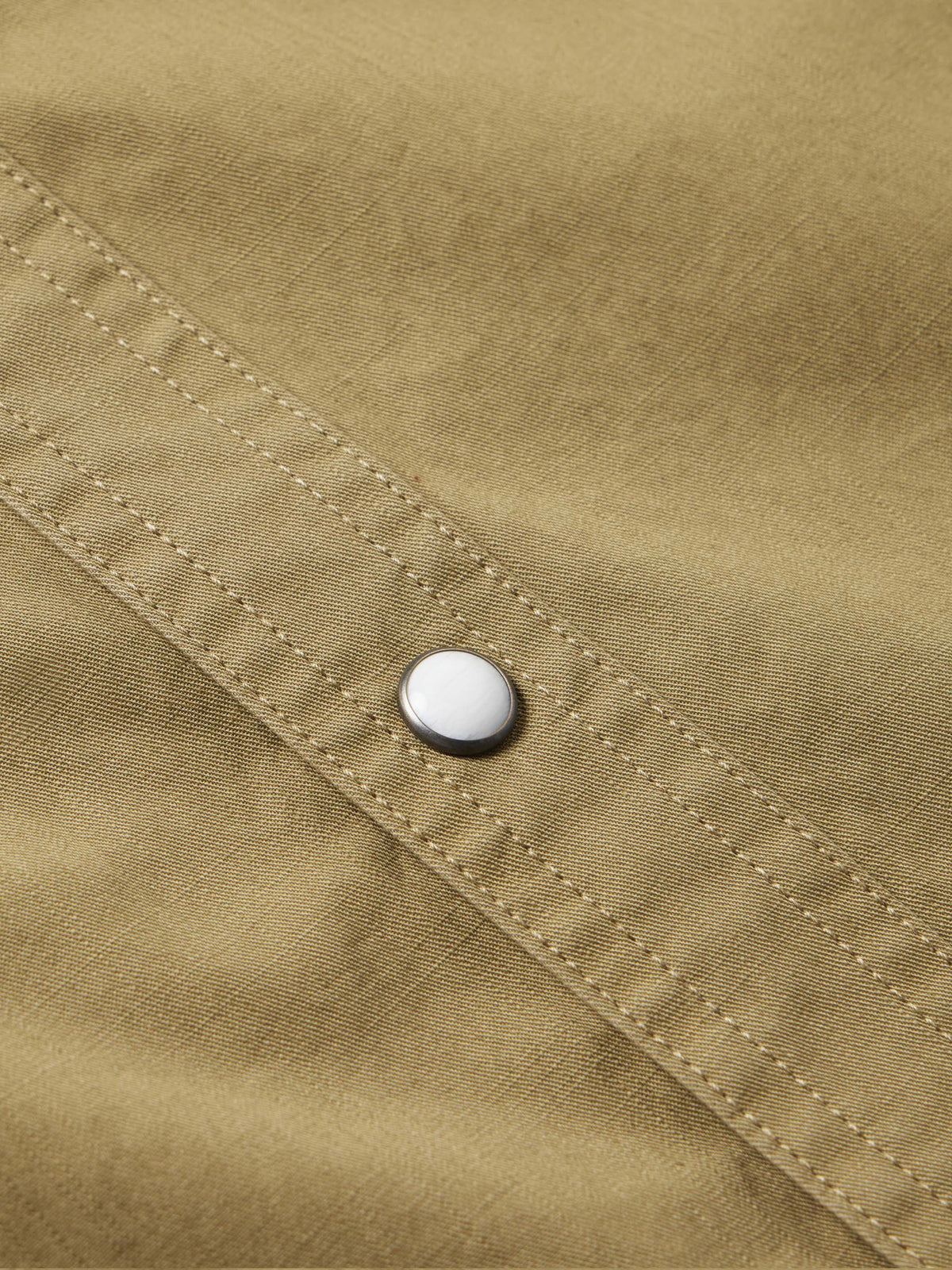 Olive slub twill shirt showing snap closure on stitched cuff placket