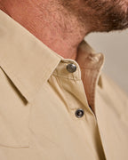 Khaki slub twill shirt cuff detail: snap button and metal tab closure.