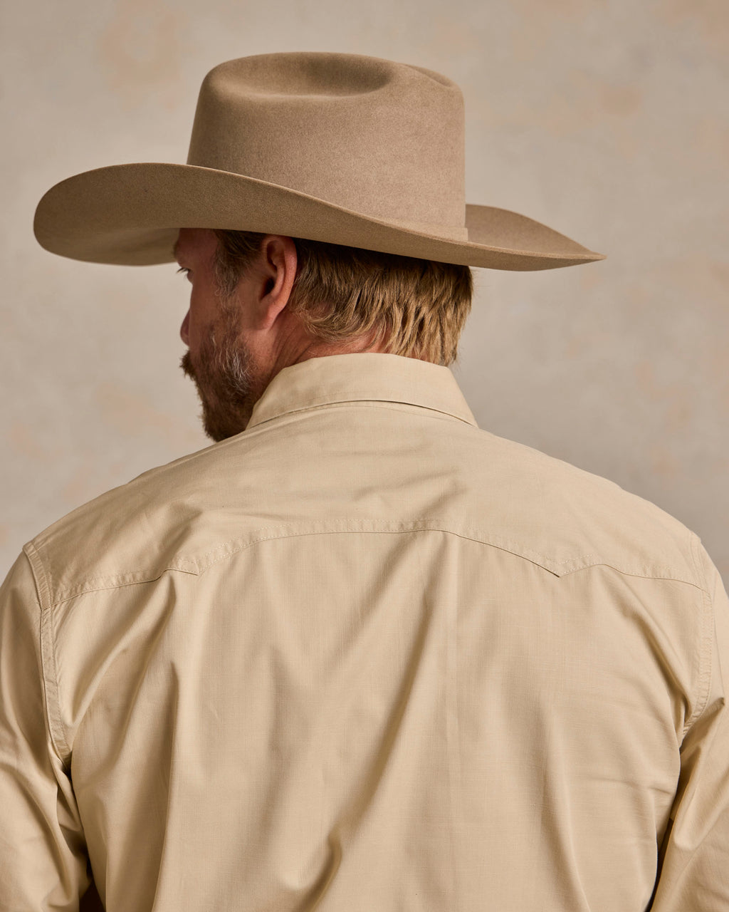 Khaki slub twill shirt back view with yoke seam and long sleeves.