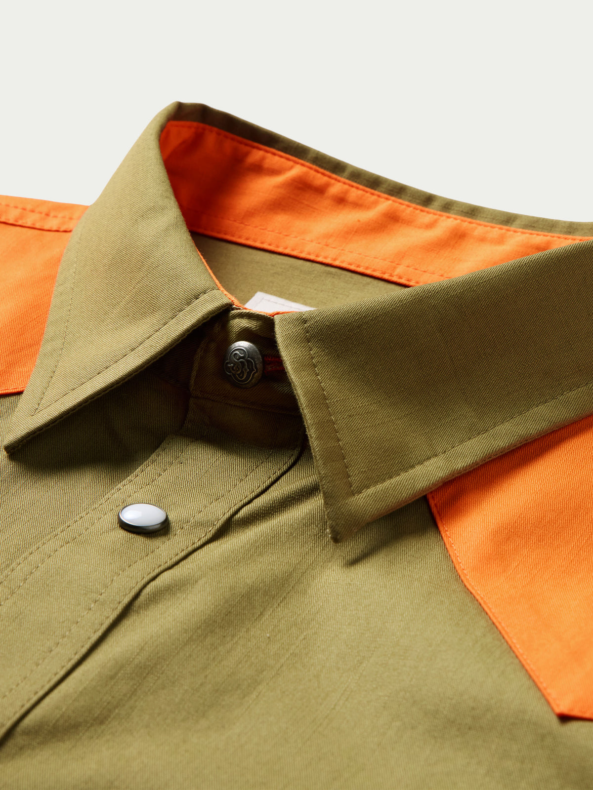 Olive slub twill shirt with orange inner collar and placket, snap button detail