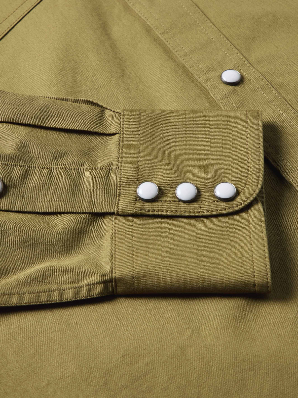 Olive slub twill shirt showing chest pocket flaps with white snap buttons