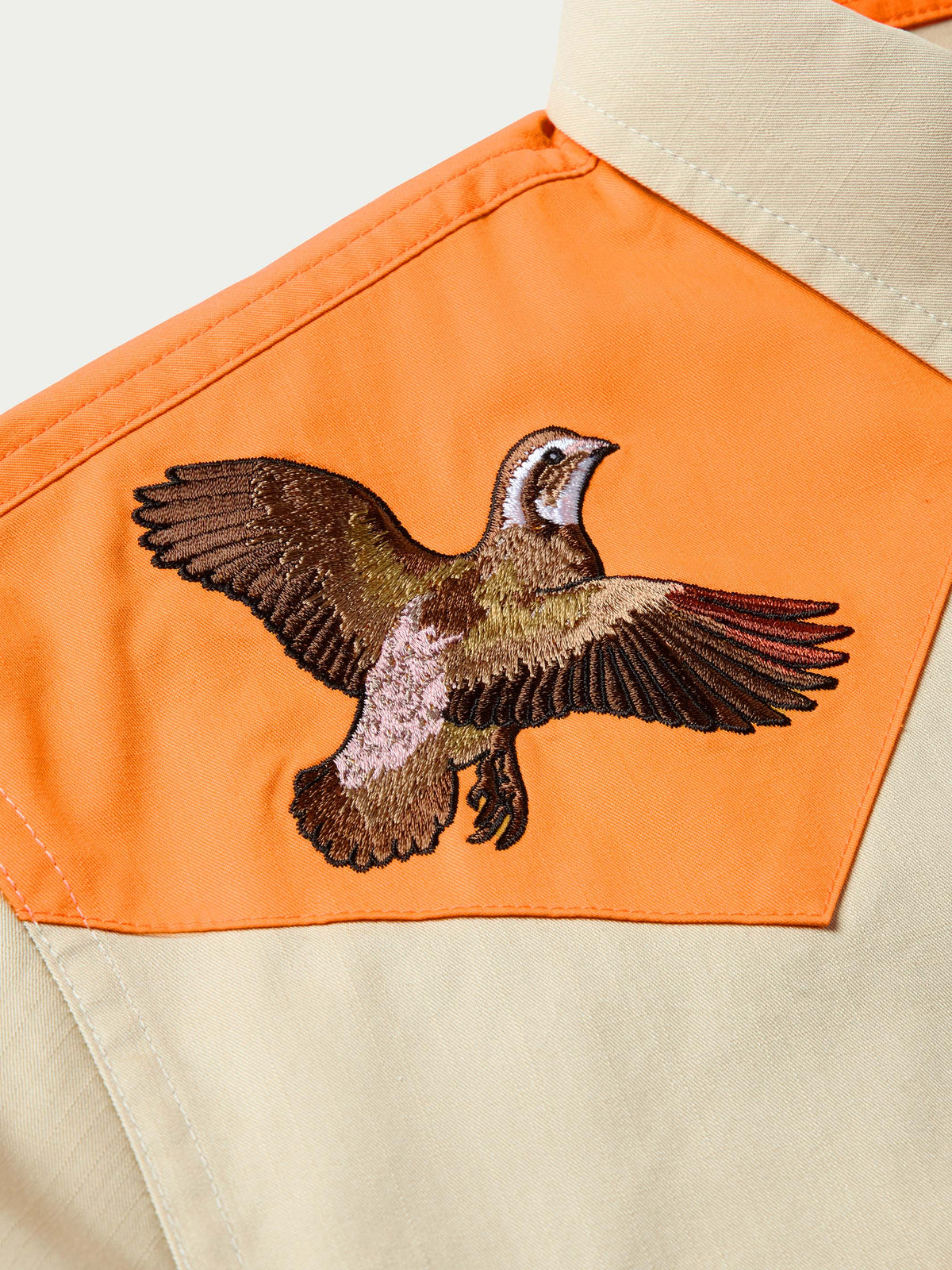 Bird embroidery on orange yoke panel of quail twill shirt